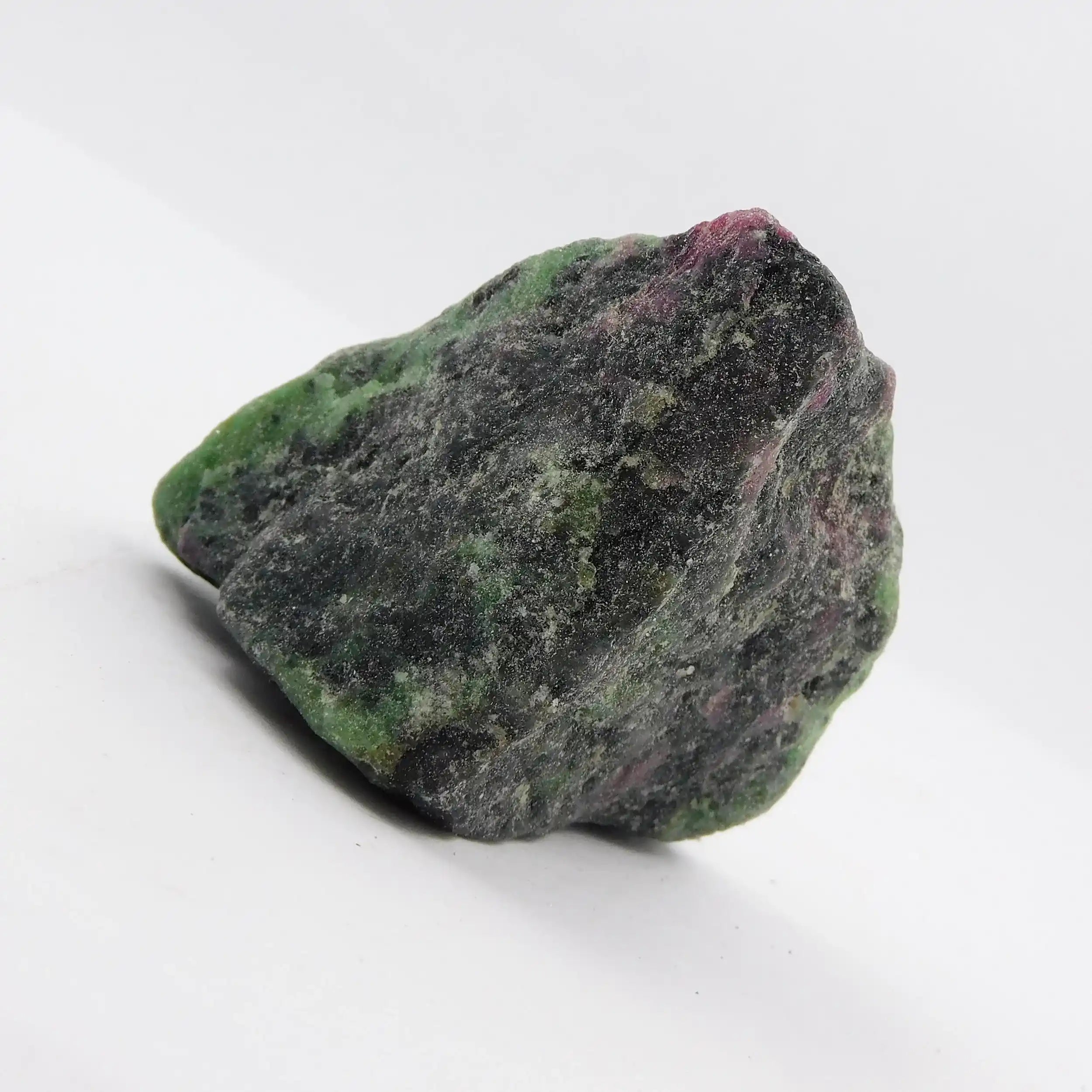 Raw green and purple stone on a white background