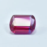 Faceted gemstone with pink and purple hues on a white background