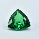 Trillion-cut green gemstone on a light gray background