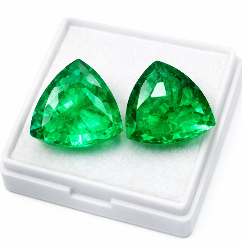 Two green gemstones in a white display case