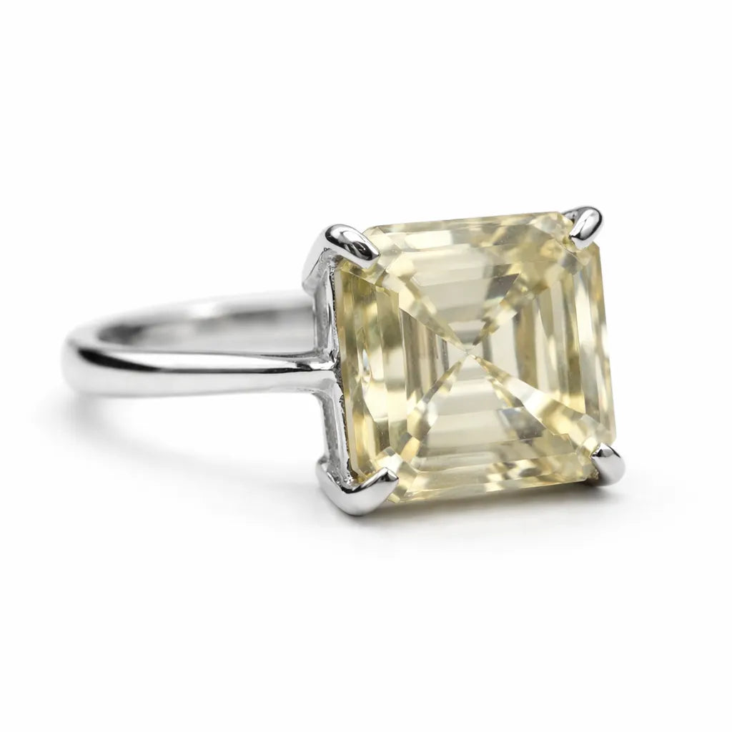 Ring with a square-cut yellow gemstone on a white background