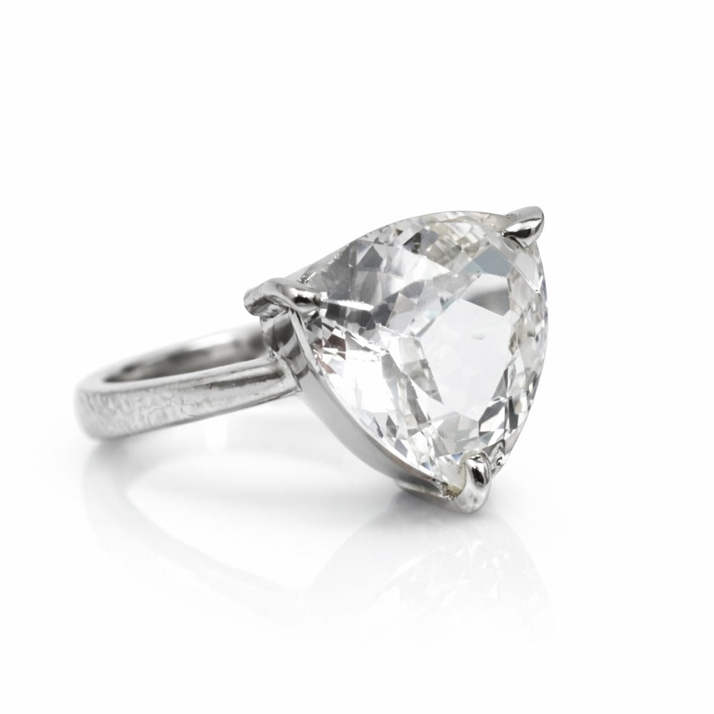 Silver ring with a large pear-shaped diamond on a white background