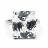 Silver ring with a large, clear gemstone on a white background
