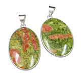 Two oval-shaped gemstone pendants with a green and red pattern on a white background.
