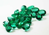 Emeralds photographed from right angle on white base
