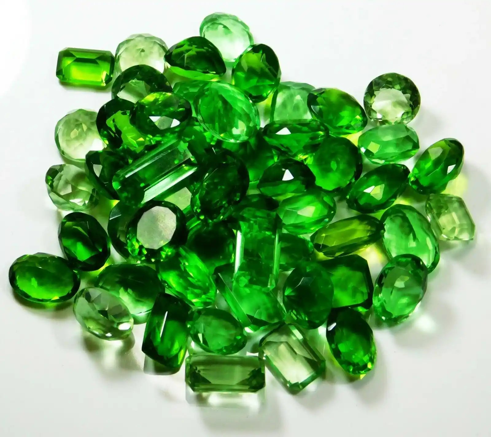 Pile of green gemstones on a white background