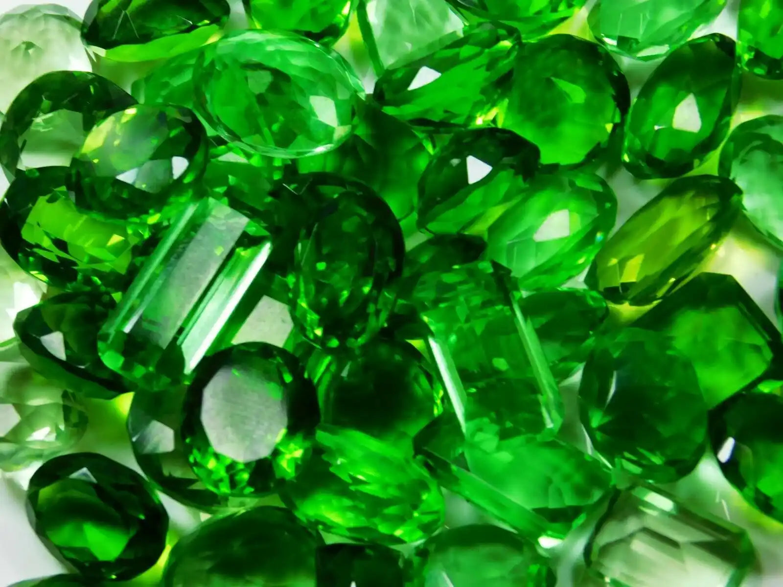 Close-up of green gemstones on a white background
