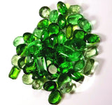 Pile of green gemstones on a white background