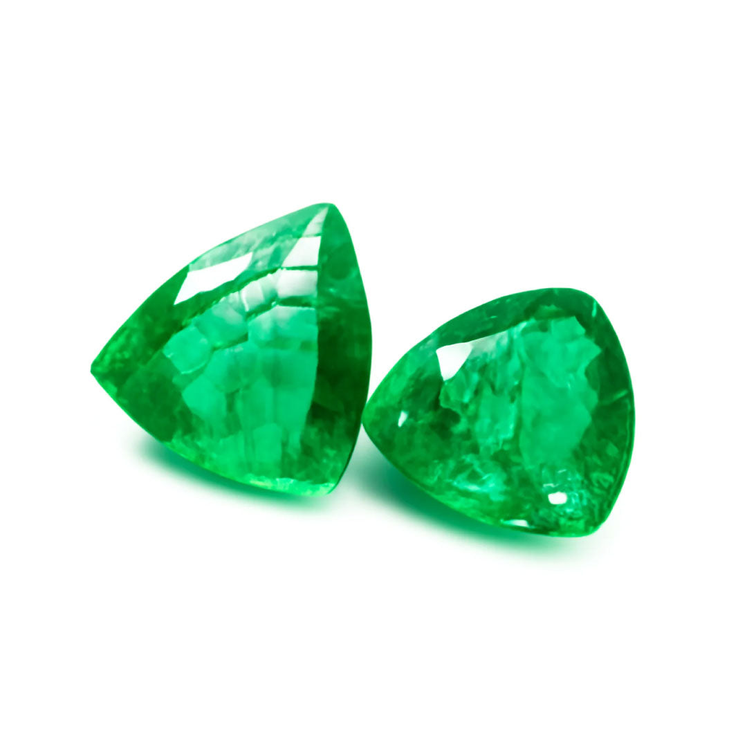 Two green gemstones on a white background