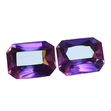 Two purple gemstones with a white background