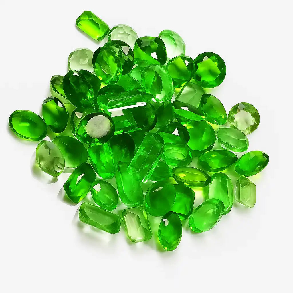Pile of green gemstones on a white background